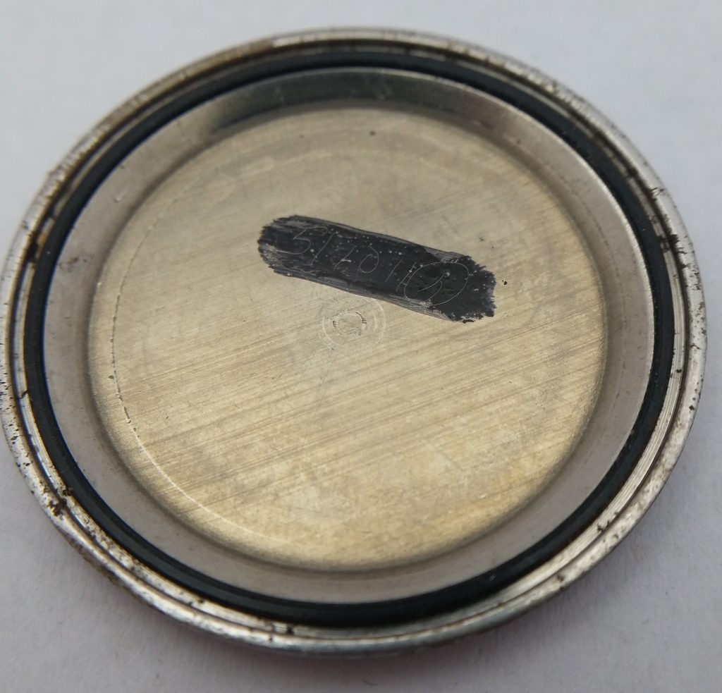 inside of case back showing watchmakers etching, and rotor damage.